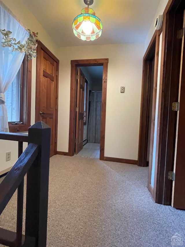 hallway featuring light colored carpet