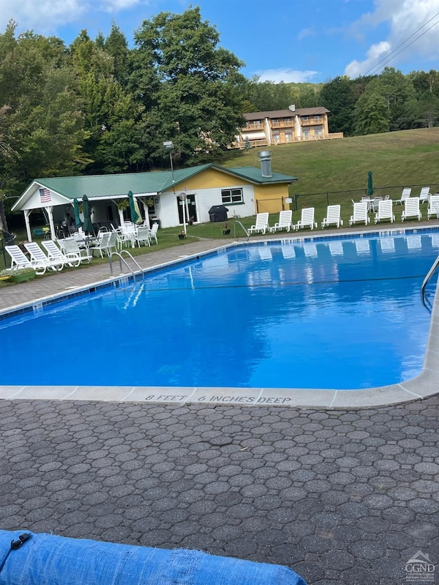 view of swimming pool featuring a patio area and a yard