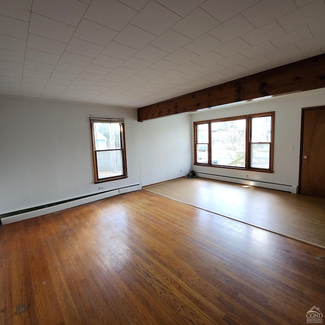 empty room with baseboard heating and light wood-type flooring