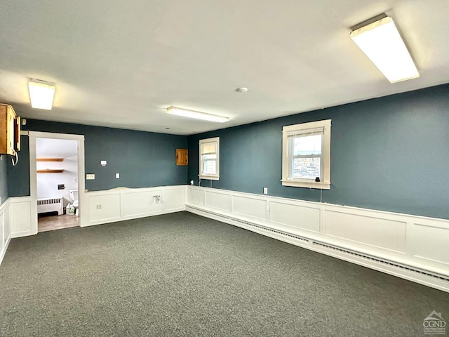 unfurnished room with radiator heating unit and carpet floors