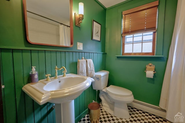 bathroom featuring baseboard heating, walk in shower, and toilet