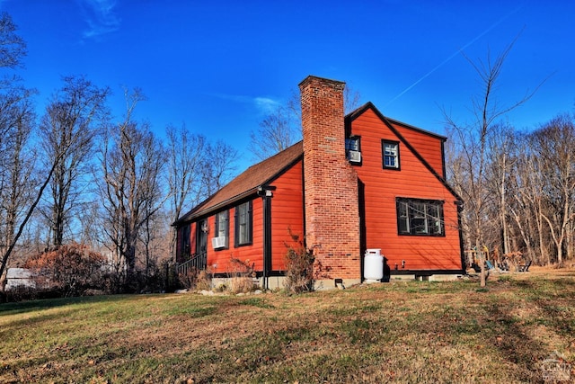 view of side of property featuring a lawn and cooling unit