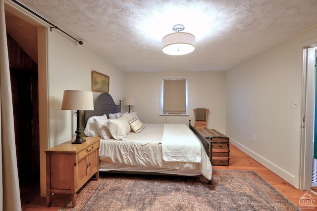 bedroom with wood-type flooring and a textured ceiling