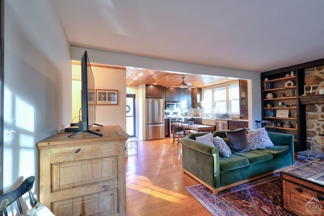 living room featuring built in features, wooden ceiling, and light hardwood / wood-style flooring