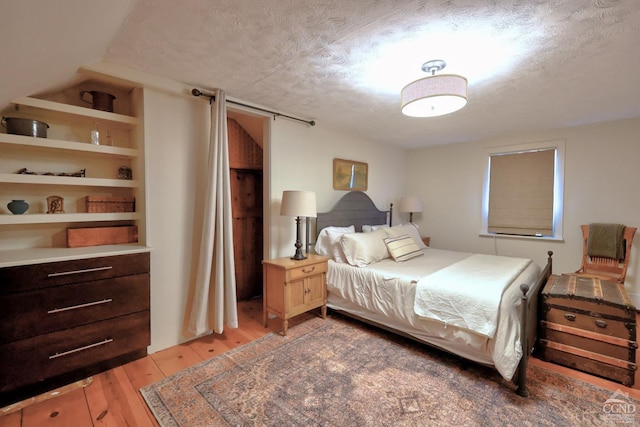 bedroom with wood-type flooring and a textured ceiling