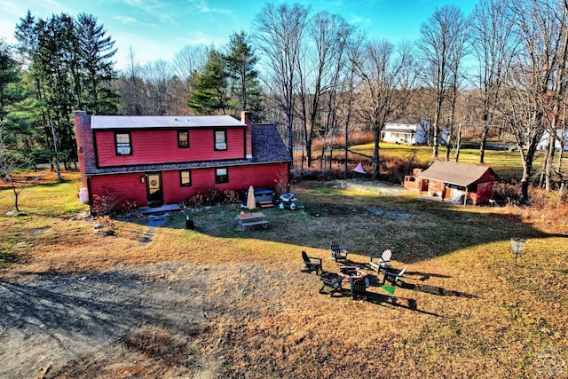 exterior space featuring a front lawn and a fire pit