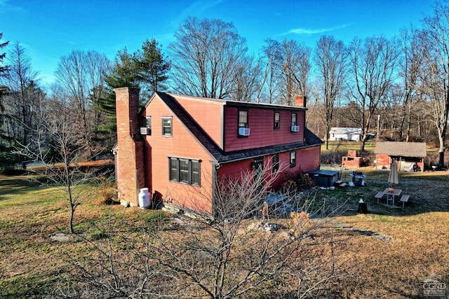 view of side of home with cooling unit and a yard