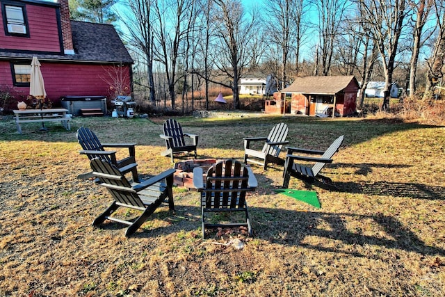 view of yard with a fire pit and an outbuilding