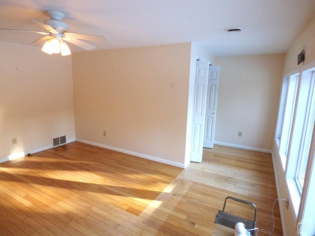 spare room with light wood-type flooring and ceiling fan