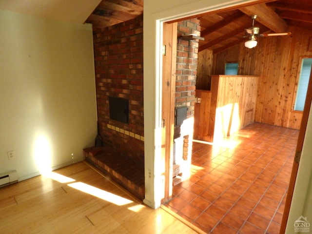 unfurnished living room featuring ceiling fan, vaulted ceiling with beams, light hardwood / wood-style flooring, wooden walls, and wood ceiling