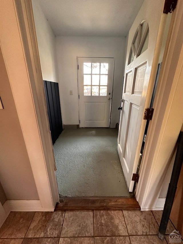 doorway to outside with tile patterned floors