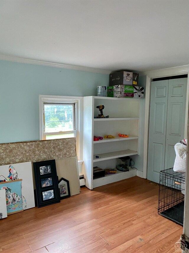 mudroom with light hardwood / wood-style floors, baseboard heating, and ornamental molding