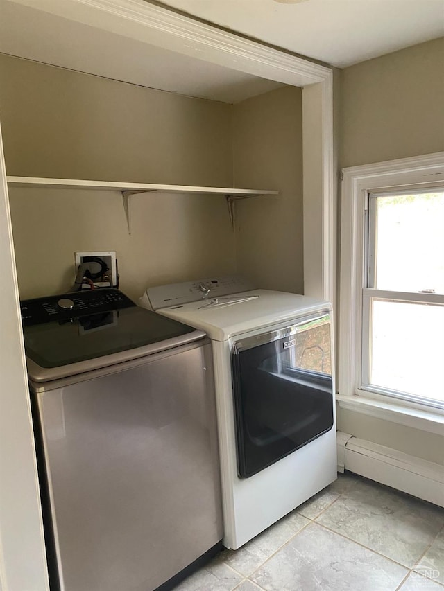 laundry area with separate washer and dryer, baseboard heating, and light tile patterned floors