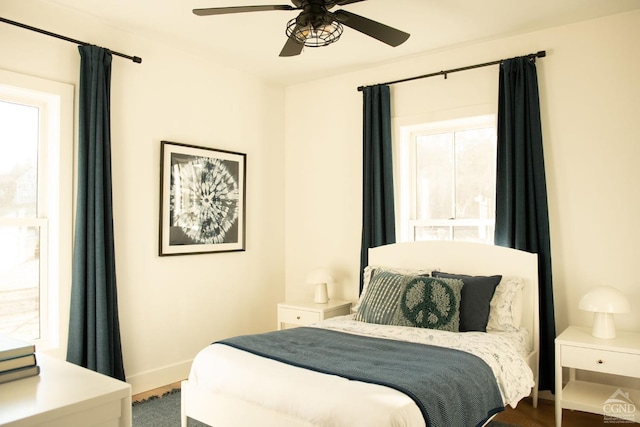 bedroom with ceiling fan, multiple windows, and hardwood / wood-style floors