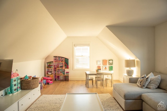 recreation room featuring vaulted ceiling and light hardwood / wood-style flooring