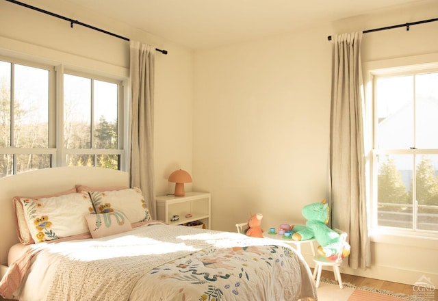 bedroom with hardwood / wood-style flooring and multiple windows