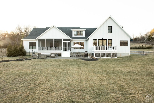 back of property featuring a yard, a patio, and a sunroom