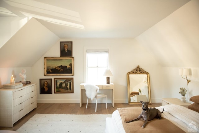 bedroom with vaulted ceiling and light hardwood / wood-style floors