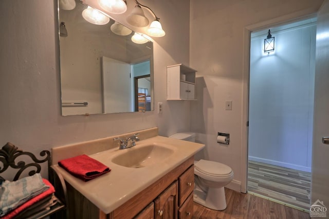 bathroom with vanity, hardwood / wood-style flooring, and toilet