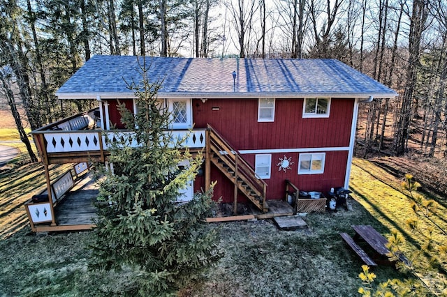 rear view of house with a deck and a yard