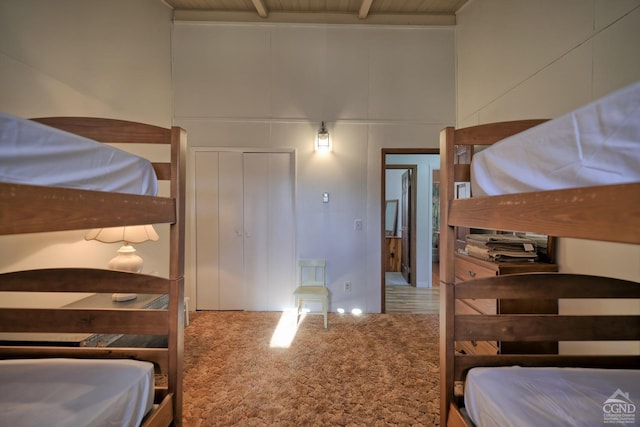 carpeted bedroom featuring beam ceiling