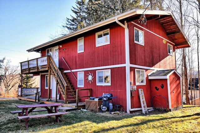 rear view of property with a deck and a yard