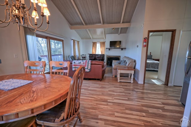 dining space featuring hardwood / wood-style floors, vaulted ceiling with beams, a notable chandelier, and wood ceiling