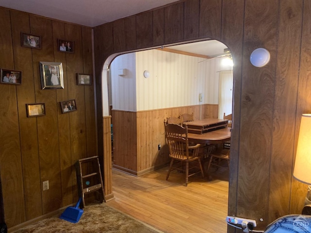 dining space with wood walls and light wood-type flooring