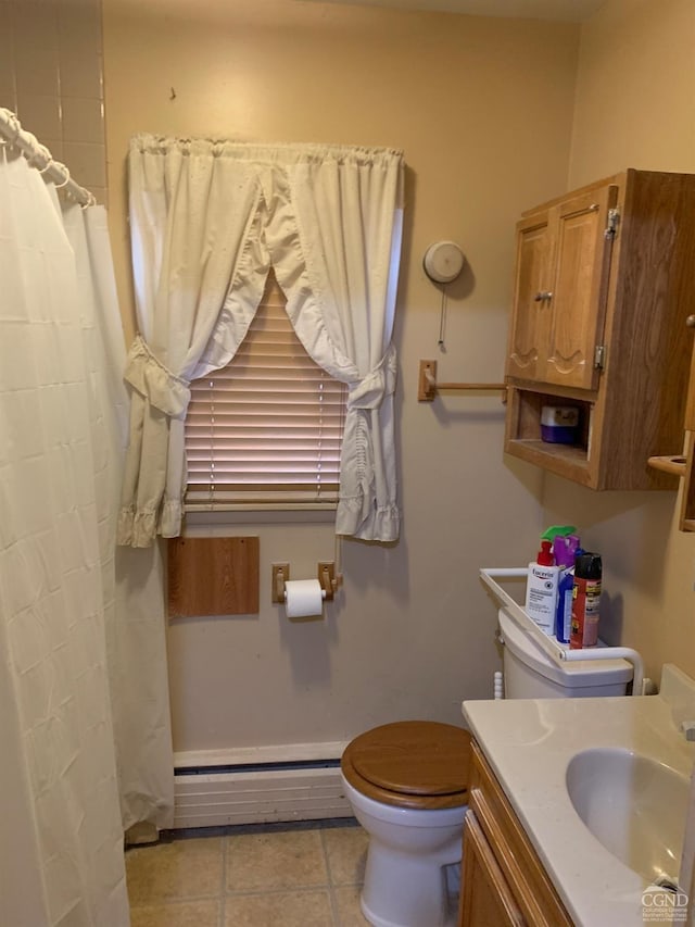 bathroom featuring toilet, vanity, a baseboard radiator, and tile patterned floors