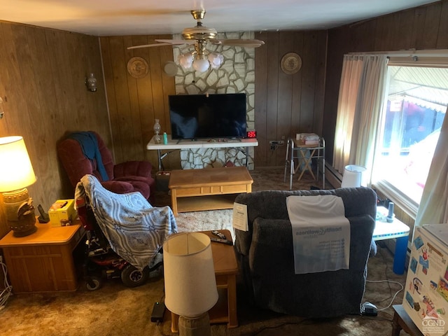 living room with carpet flooring, ceiling fan, and wooden walls