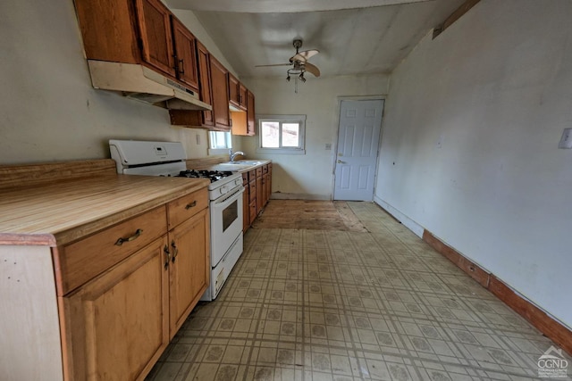 kitchen with ceiling fan, white range with gas stovetop, and sink