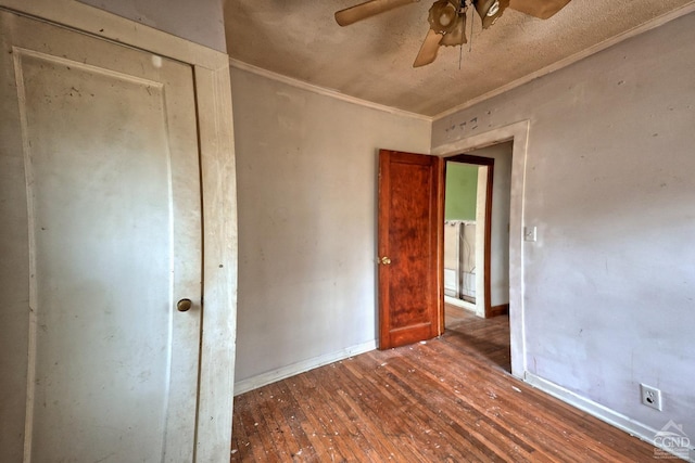 empty room with dark hardwood / wood-style floors, ceiling fan, and crown molding