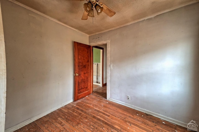 spare room with dark hardwood / wood-style flooring, ceiling fan, and crown molding