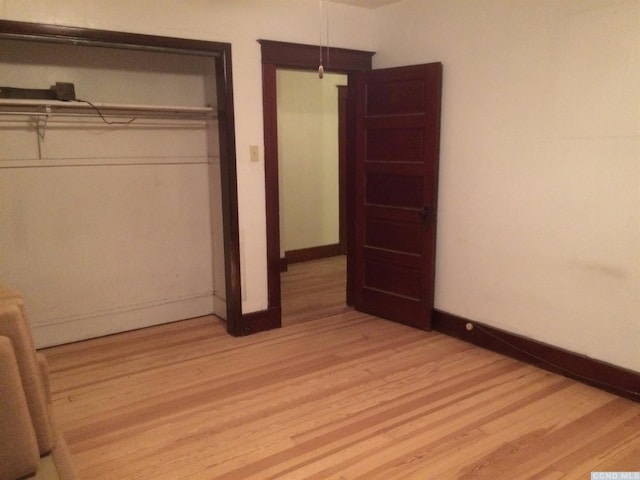 unfurnished bedroom with baseboards and light wood-style floors