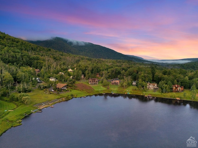 aerial view at dusk featuring a water and mountain view