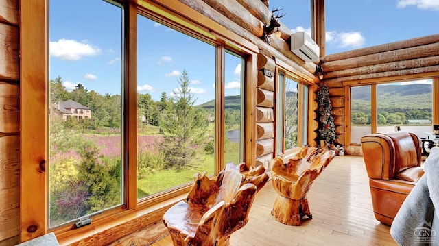 sunroom / solarium featuring a wall mounted AC and plenty of natural light