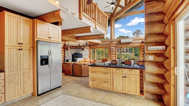 kitchen featuring log walls, stainless steel fridge, a wall mounted air conditioner, and ceiling fan