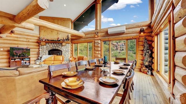 dining area with hardwood / wood-style floors, a wall mounted air conditioner, a high ceiling, rustic walls, and a fireplace