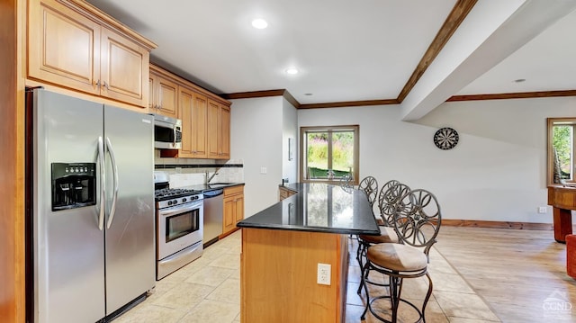 kitchen with stainless steel appliances, backsplash, a breakfast bar area, a kitchen island, and light wood-type flooring