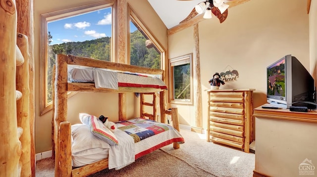 carpeted bedroom with ceiling fan and vaulted ceiling