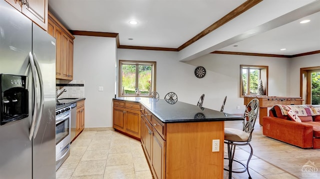 kitchen with backsplash, a kitchen breakfast bar, dark stone countertops, appliances with stainless steel finishes, and kitchen peninsula