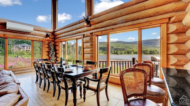 sunroom featuring a wall mounted air conditioner and a water and mountain view