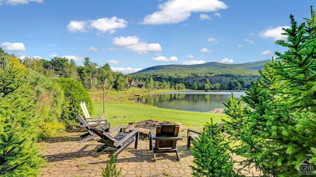 view of yard featuring a patio area, a water and mountain view, and an outdoor fire pit