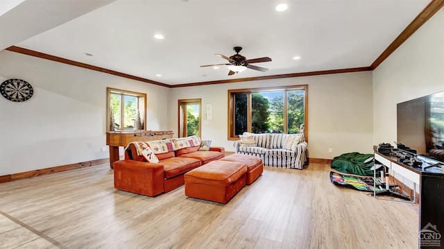 living room featuring a wealth of natural light, light hardwood / wood-style flooring, ceiling fan, and crown molding