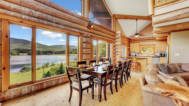 sunroom featuring a wealth of natural light, lofted ceiling, ceiling fan, and a water and mountain view