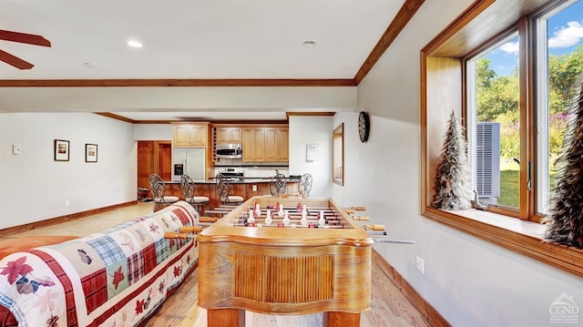 interior space featuring crown molding, light hardwood / wood-style flooring, ceiling fan, and a healthy amount of sunlight