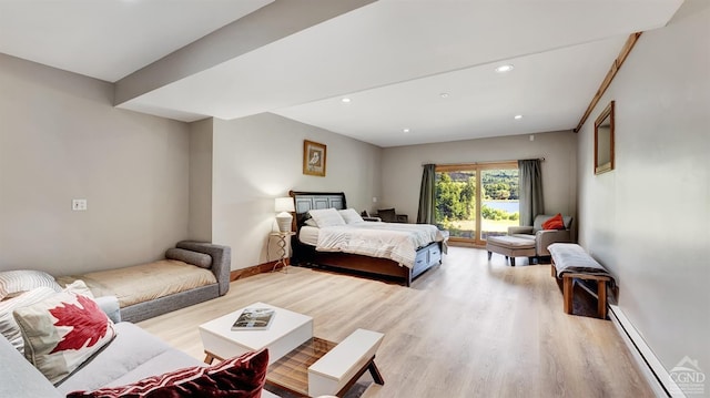 bedroom with baseboard heating, access to exterior, and light hardwood / wood-style floors