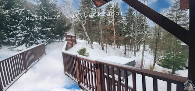 view of snow covered back of property