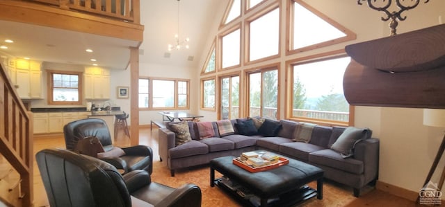 living room with high vaulted ceiling and a notable chandelier