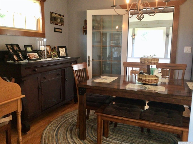 dining area featuring wood finished floors and a notable chandelier